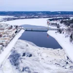 Beautiful winter landscape with buildings and a bridge over Ounasjoki River in Rovaniemi, Finland